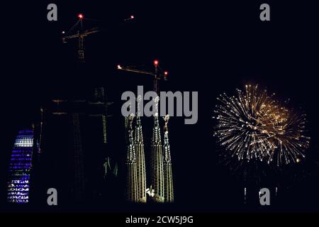 Barcelone, Espagne. 27 septembre 2020. Des feux d'artifice éclatant au-dessus du ciel nocturne sont vus à côté de la basilique de la Sagrada Familia lors d'un spectacle de feux d'artifice à la fin du festival de la ville de Barcelone, la Merce. En raison de la pandémie du coronavirus, cette année, 'merce' a eu lieu sous une forme très réduite et les feux de feu traditionnels marquant la fin du festival devant les Fontaines Montjuic, qui attirent normalement des dizaines de milliers, ont été remplacés par quatre plus petits écrans distribués sur la zone de la ville à voir Depuis les balcons et les toits crédit: Matthias Oesterle/Alamy Live News Banque D'Images