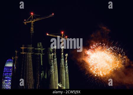 Barcelone, Espagne. 27 septembre 2020. Des feux d'artifice éclatant au-dessus du ciel nocturne sont vus à côté de la basilique de la Sagrada Familia lors d'un spectacle de feux d'artifice à la fin du festival de la ville de Barcelone, la Merce. En raison de la pandémie du coronavirus, cette année, 'merce' a eu lieu sous une forme très réduite et les feux de feu traditionnels marquant la fin du festival devant les Fontaines Montjuic, qui attirent normalement des dizaines de milliers, ont été remplacés par quatre plus petits écrans distribués sur la zone de la ville à voir Depuis les balcons et les toits crédit: Matthias Oesterle/Alamy Live News Banque D'Images