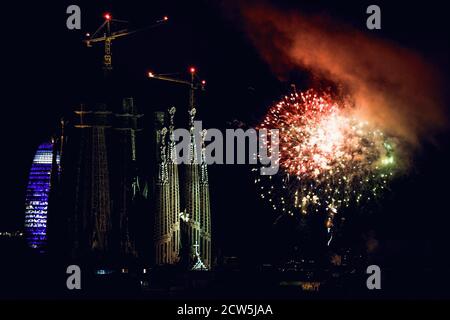 Barcelone, Espagne. 27 septembre 2020. Des feux d'artifice éclatant au-dessus du ciel nocturne sont vus à côté de la basilique de la Sagrada Familia lors d'un spectacle de feux d'artifice à la fin du festival de la ville de Barcelone, la Merce. En raison de la pandémie du coronavirus, cette année, 'merce' a eu lieu sous une forme très réduite et les feux de feu traditionnels marquant la fin du festival devant les Fontaines Montjuic, qui attirent normalement des dizaines de milliers, ont été remplacés par quatre plus petits écrans distribués sur la zone de la ville à voir Depuis les balcons et les toits crédit: Matthias Oesterle/Alamy Live News Banque D'Images