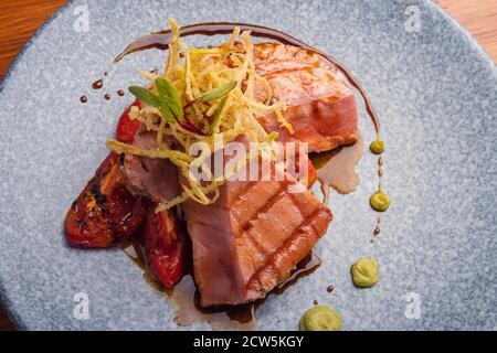 Filet de thon sur une parrilla avec jitomate rostisé dans une assiette de marmol. Banque D'Images