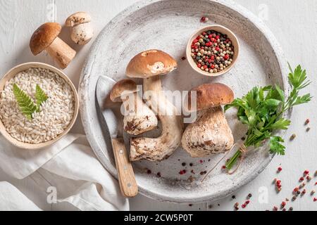 Ingrédients pour risotto maison avec des champignons et du persil table en bois Banque D'Images