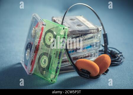 Pile rétro de cassettes avec casque orange sur fond bleu canapé Banque D'Images