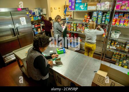 Des volontaires caucasiens et afro-américains au pantry alimentaire de charité d'une église catholique de Californie du Sud organisent des dons alimentaires. Banque D'Images