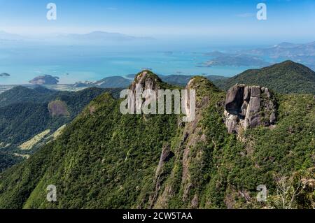 Vue imprenable sur les trois pics de formation rocheuse couverts de la végétation verte de Serra do Mar avec la côte de baie de Carioca à l'arrière-plan. Banque D'Images