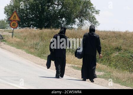 Religieuses chrétiennes orthodoxes marchant sur une route en Roumanie Banque D'Images