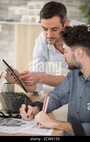 groupe de deux collègues travaillant avec blueprint au bureau Banque D'Images