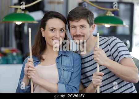 Jeune couple playing snooker ensemble dans bar Banque D'Images