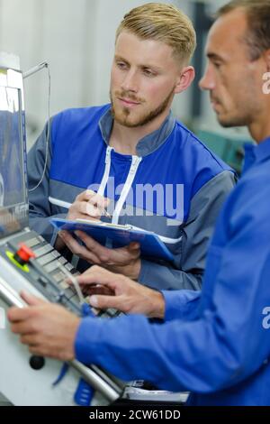 hommes utilisant des machines en usine Banque D'Images