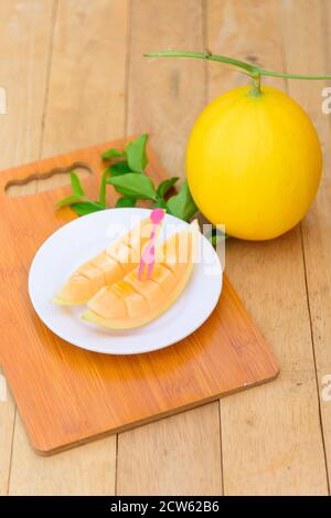 Melon doré frais sur une assiette en bois Banque D'Images