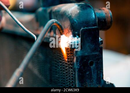 Soudeurs radiateur de voiture en cuivre avec chalumeau à gaz Banque D'Images