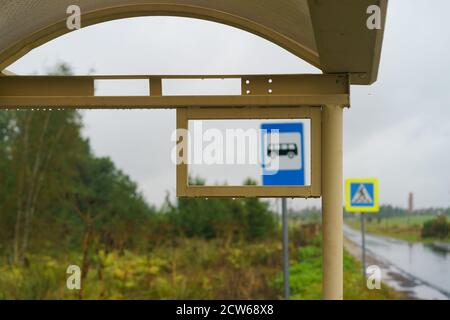 L'automne arrive dans la campagne russe. Route humide dans la journée. Douche froide. Arrêts de bus vides. Panneaux indiquant le passage pour piétons et les transports en commun s Banque D'Images