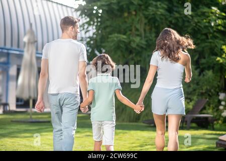 Homme femme et enfant de l'école marchant avec dos à la caméra Banque D'Images