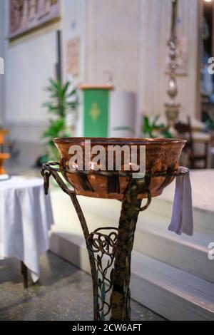 police baptismale dans l'église catholique en italie pour le baptême en cuivre sur piédestal. Photo de haute qualité Banque D'Images