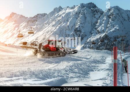 Rattar moderne rouge avec chasse-neige machine de préparation de pistes de ski alpin à la station de ski alpin d'hiver Ischgl en Autriche. Lourd Banque D'Images