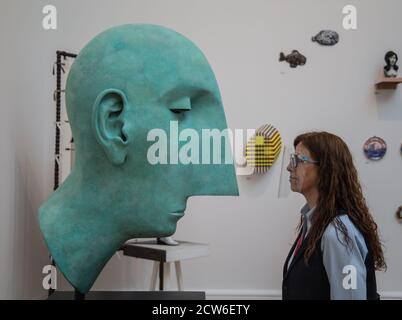 Londres Royaume-Uni 28 septembre 2020 pour la première fois, en raison de la COVID-19, l'exposition d'été aura lieu à l'automne. Présentation de plus de 1000 œuvres dans un large éventail de médias, par des artistes émergents et établis. Assistant de galerie regardant la tête 11 par Tim Shaw. Paul Quezada-Neiman/Alamy Live News Banque D'Images