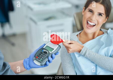 Femme adulte payant la visite au cabinet de dentiste Banque D'Images