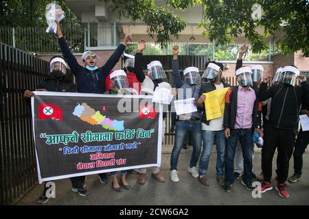 Katmandou, Népal. 28 septembre 2020. Des manifestants portant un masque facial tiennent une bannière et des pancartes tout en scandant des slogans pendant la manifestation devant l'ambassade chinoise à Katmandou.UN groupe de la société civile au Népal a lancé des manifestations contre la Chine pour avoir soi-disant construit des bâtiments sur le territoire du pays dans le district de Humla. Les activistes ont scandé des slogans tels que « Return Nepal's Land » et « top expansionnisme chinois ». Crédit : SOPA Images Limited/Alamy Live News Banque D'Images