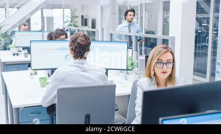 Dans les rangs de bureaux très occupés de divers professionnels travaillant sur des ordinateurs de bureau, faire le support client, communiquer avec les clients, surveillance Banque D'Images