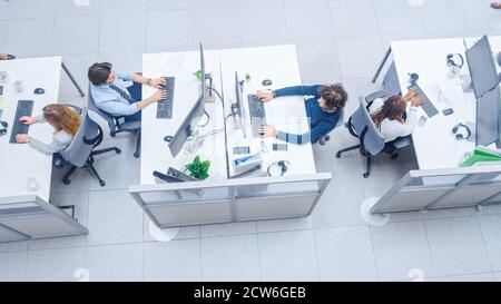 Dans les rangs de bureaux très occupés de divers professionnels travaillant sur des ordinateurs de bureau, parler, faire le support client, communiquer avec les clients Banque D'Images