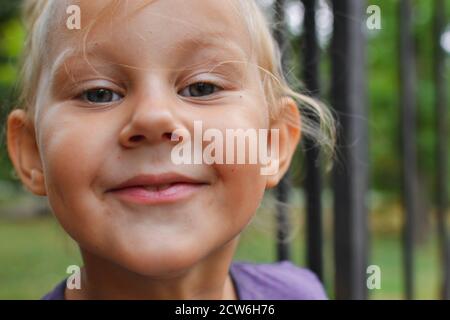 Portrait d'un enfant mignon gros plan. Souriant petite fille mignonne regardant l'appareil photo. Banque D'Images