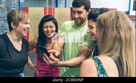 Les athlètes à la recherche au mobile d'une salle de sport mate Banque D'Images
