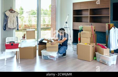 Man unpacking moving boxes Banque D'Images