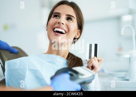 Femme adulte payant la visite au cabinet de dentiste Banque D'Images