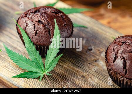 Médicaments marijuana chanvre drogues dans la nourriture dessert, ganja légalisation. Cuisson des muffins aux mauvaises herbes au chocolat. Cupcake avec de la marijuana. Gâteau au chocolat Banque D'Images