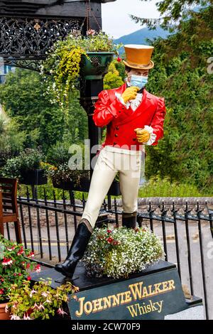 Johnnie Walker, statue annonçant le whisky, portant un masque pendant le coronavirus (COVID-19), Inverness, Écosse Banque D'Images