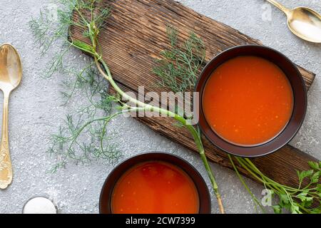 Soupe de tomates dans un bol noir sur fond de pierre grise. Copier l'espace.vue de dessus. Banque D'Images