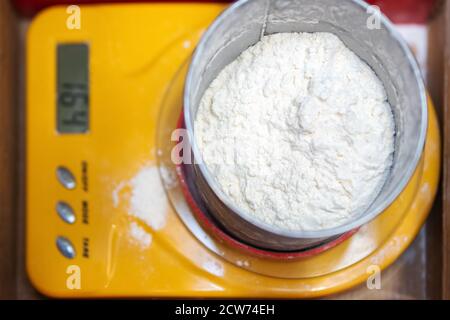 Bol avec farine sur balance de cuisine Banque D'Images