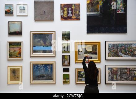 NOTE AUX ÉDITEURS. POUR UTILISATION DANS LE CADRE DE L'EXPOSITION UNIQUEMENT. Un membre du public photographie diverses œuvres lors d'un avant-goût de l'exposition « summer » à la Royal Academy of Arts de Londres. La 252e exposition d'été a été reportée en raison de la pandémie du coronavirus et aura lieu à l'automne pour la première fois. Banque D'Images