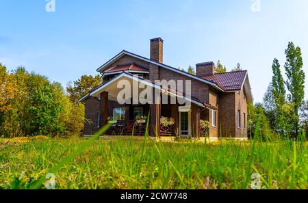 extérieur d'une maison de campagne de deux étages en briques brunes avec un toit en mansarde. Banque D'Images
