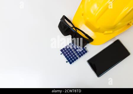 Image du concept d'énergie des cellules solaires. Panneau solaire, casque de sécurité et outils de travail isolés sur fond blanc, vue du dessus Banque D'Images