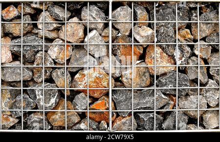 Une cage en acier de roches de forme aléatoire et de couleur. Banque D'Images