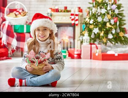 Fille en chapeau Santas rouge avec bonbons Banque D'Images