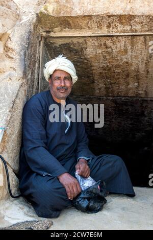 Un égyptien est assis à l'entrée du tunnel qui mène à la troisième chambre funéraire à l'intérieur de la pyramide rouge à Dahshur en Égypte. Banque D'Images