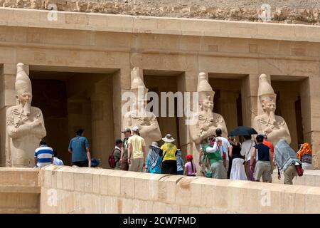 Les touristes s'approchent des piliers Osirid sur la terrasse supérieure du temple mortuaire d'Hatshepsut à Deir al-Bahri près de Louxor dans le centre de l'Égypte. Banque D'Images