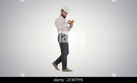 Homme mûr confiant en tenue de forme et casque de chantier écrivant note Banque D'Images
