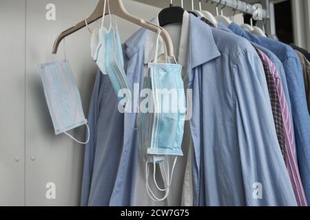 Différents masques de protection suspendus avec des vêtements Banque D'Images