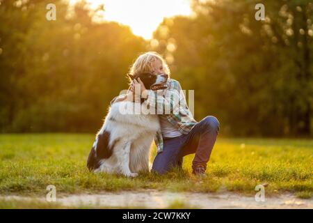 Petit garçon jouant avec son chien à l'extérieur dans le parc Banque D'Images