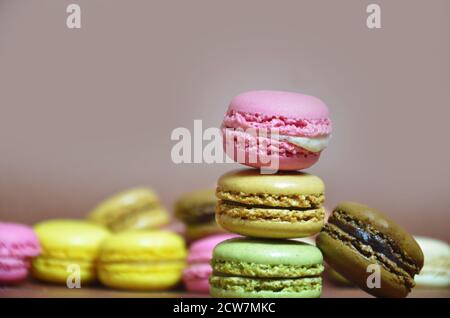 Macarons colorés et savoureux de suite. Macarons de différentes couleurs sur fond marron Banque D'Images