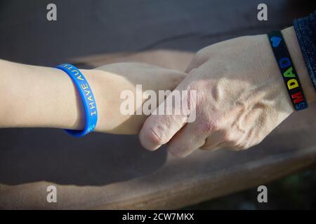 Sensibilisation à l'autisme. Père tenant la main son enfant autiste. Banque D'Images