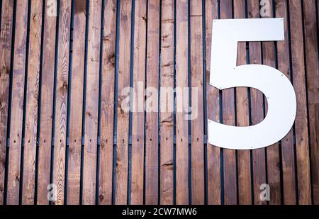 Un grand nombre blanc « cinq » sur la surface en bois. Arrière-plan des panneaux étroits. Banque D'Images