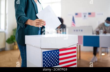 Une femme méconnaissable a mis son vote dans les urnes, aux états-unis et aux élections du coronavirus. Banque D'Images