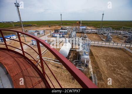 Gisement de pétrole de Zhaik-Munai, Kazakhstan. Usine de raffinage de pétrole. Vue de la colonne de raffinage de pétrole. Échangeurs thermiques, mâts, pipelines dans les sables. Ciel bleu Banque D'Images