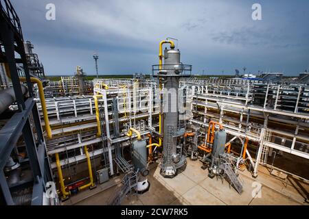 Tours de distillation (colonnes), tuyaux et système de canalisations. Raffinerie de pétrole et usine de traitement du gaz. Fond bleu ciel. Banque D'Images