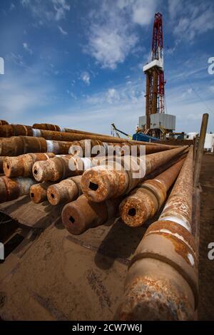 Gisement de pétrole de Zhaik-Munai, Kazakhstan. Equipement de forage pétrolier et tuyaux de forage rouillés. Sur un ciel bleu avec des nuages. Banque D'Images