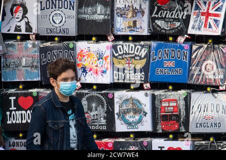 Un homme portant un masque facial protecteur passe devant des souvenirs touristiques sur le thème de Londres en vente à Westminster, Londres, après qu'une série de nouvelles restrictions visant à lutter contre l'augmentation des cas de coronavirus sont entrées en vigueur en Angleterre. Banque D'Images