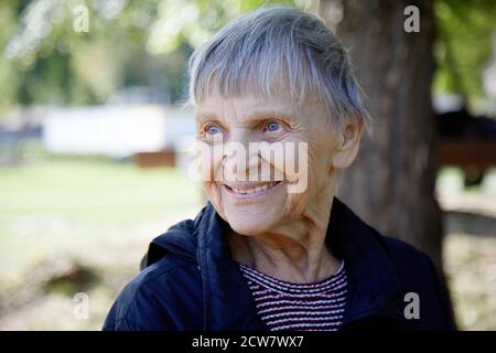 Portrait d'une femme de quatre-vingt-dix ans souriant dans le parc. Banque D'Images